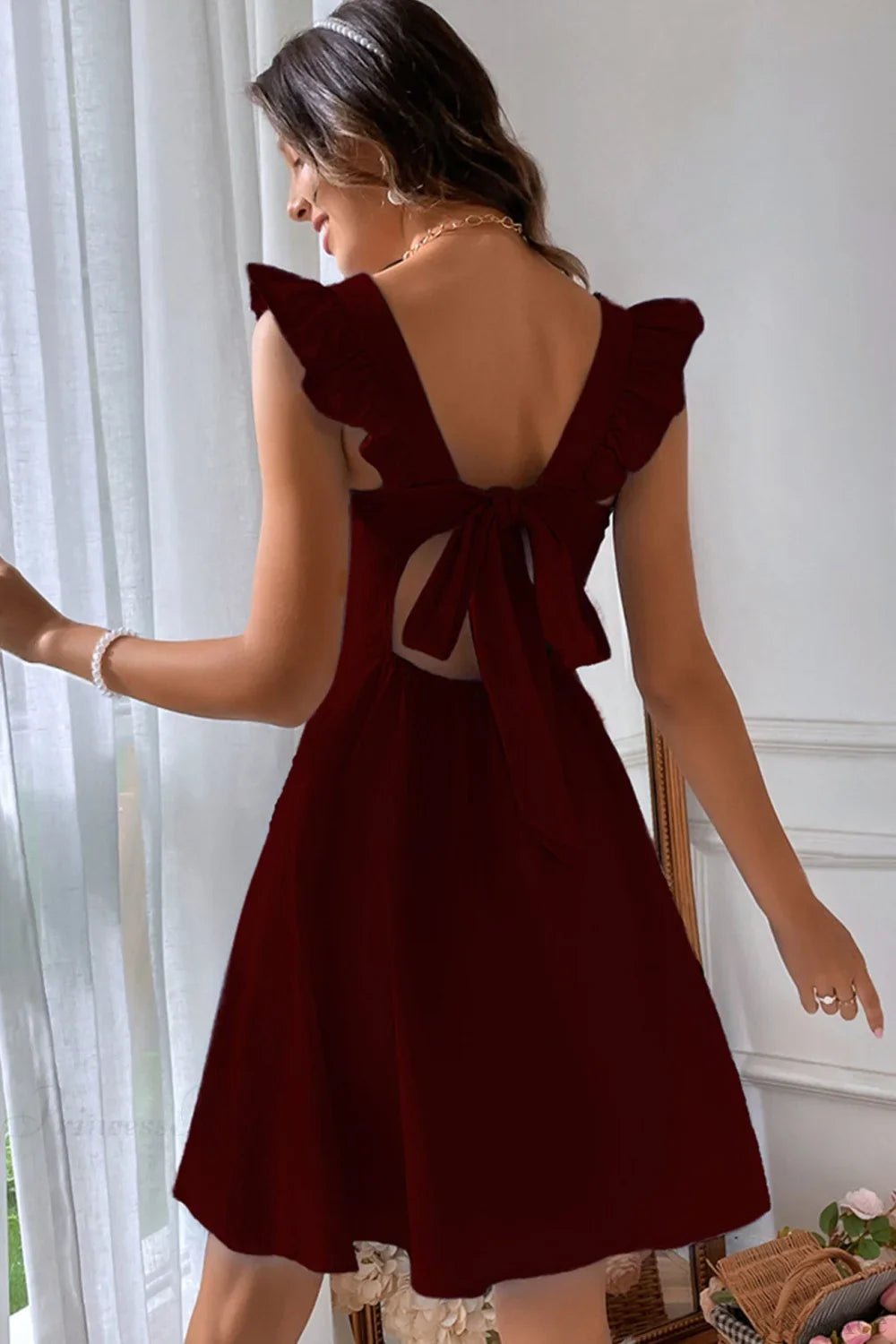 Carmen mini robe sans manches avec nœud volanté au dos